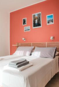 a bedroom with a bed with an orange wall at Magna Grecia B&B e Appartamenti in Caulonia Marina