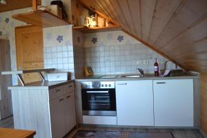 a kitchen with white cabinets and a sink and an oven at Gästehaus Klein in Hilders