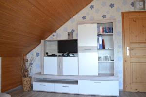 a living room with a tv on a wall at Gästehaus Klein in Hilders