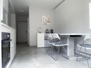 a kitchen with white appliances and white stools at Holiday House Promenade in Lunz am See
