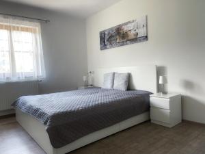 biała sypialnia z łóżkiem i 2 lampami w obiekcie Holiday House Promenade w mieście Lunz am See