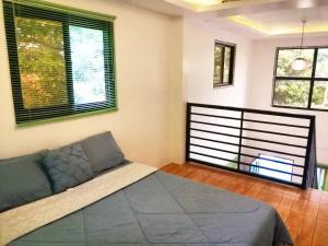a bedroom with a bed and two windows at Purple Orchid Bed and Breakfast in Tagaytay