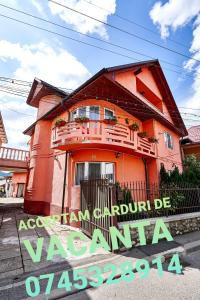 a orange house with a sign in front of it at Camere de inchiriat ROMAN in Vişeu de Sus