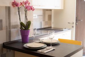stół z dwoma kieliszkami i wazon z kwiatami w obiekcie Speranza apartment 2 w Krku
