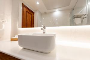 a white bathroom with a sink and a mirror at Toboso Apar - Turis in Nerja