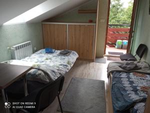 Pokój z dwoma łóżkami, stołem i drzwiami w obiekcie Agroturystyka A&G Dubeninki w mieście Dubeninki