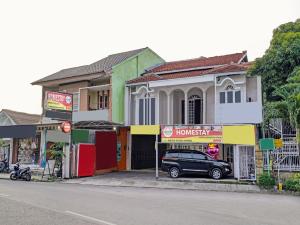 a car parked in front of a building on a street at OYO 90289 Lestari Syariah Homestay in Cirebon