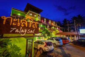 a parking lot with cars parked in front of a building at Talay Sai @ Thung Wua Laen in Pathiu