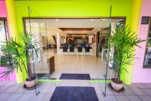 a lobby with two potted plants in a building at Talay Sai @ Thung Wua Laen in Pathiu