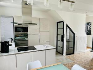a kitchen with white cabinets and a stove top oven at le numero 100 in Nancy