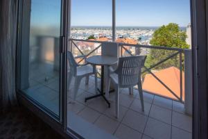 a balcony with a table and two chairs on a balcony at Hôtel Le Nautic in Arcachon