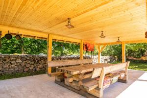 um alpendre de madeira com uma mesa e uma parede de pedra em Käbruotsa farmhouse em Ruhve