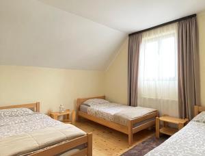 una camera da letto con due letti e una finestra di Underwoods Žabljak Guesthouse a Žabljak