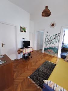 a living room with a wooden floor and white walls at Green Garden House in Gencsapáti