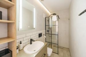 a bathroom with a sink and a glass shower at Zdrojowa 5A by Renters in Międzyzdroje