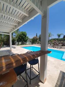 a patio with a table and chairs and a swimming pool at Morad Haharbel - Boutique Resort in Arbel