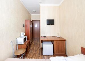 a hotel room with a desk and a microwave at RA Kuznechny 19 in Saint Petersburg