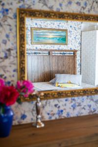 a mirror reflecting a bed in a room with flowers at Käbruotsa farmhouse in Ruhve