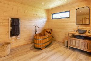 baño de madera con bañera y lavamanos en Les Lodges de Malbrough, en Aire-sur-la-Lys