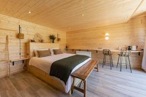 1 dormitorio con 1 cama en una cabaña de madera en Les Lodges de Malbrough, en Aire-sur-la-Lys