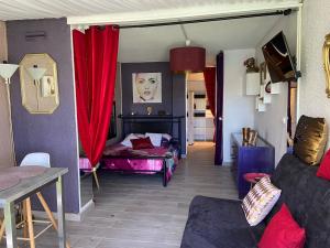 sala de estar con cortinas rojas y sofá en Purple Secret Naturiste, en Cap d'Agde