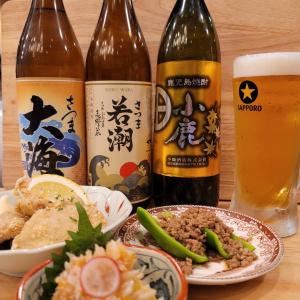 a table with three bottles of beer and a plate of food at HOTEL&HOSTEL HARU in Kanoya
