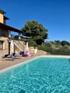 a swimming pool with two chairs and a house at CasaFè tra sogno e realtà in Narni Scalo