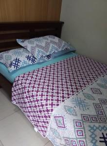 馬尼拉的住宿－貝殼公寓，床上配有被子和枕头
