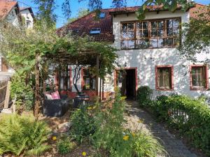 ein weißes Haus mit einem Garten davor in der Unterkunft Gästehaus Kleine Mühle in Krems an der Donau