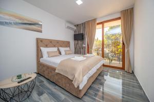 a bedroom with a large bed and a large window at Green Pino Seaview Studios in Bar