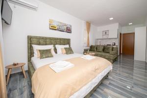a bedroom with a large bed and a couch at Green Pino Seaview Studios in Bar