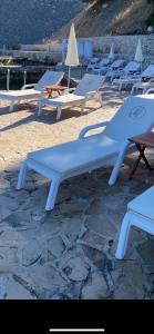 a row of lounge chairs sitting on a beach at Vila Bilo in Primošten