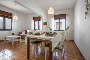una cucina e una sala da pranzo con tavolo e sedie di Casa das Flores a Vila do Bispo