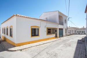 una strada vuota con un edificio bianco di Casa das Flores a Vila do Bispo