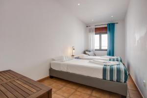 una camera da letto con un letto e un tavolo di Casa das Flores a Vila do Bispo