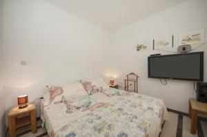 Schlafzimmer mit einem Bett und einem Flachbild-TV in der Unterkunft Apartments Kalajžić in Pučišća