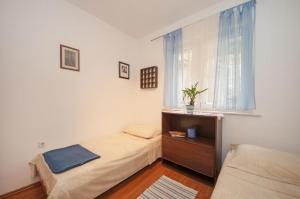 ein kleines Schlafzimmer mit 2 Betten und einem Fenster in der Unterkunft Apartments Kalajžić in Pučišća