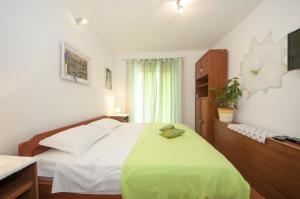 ein Schlafzimmer mit einem großen Bett und einer grünen Decke in der Unterkunft Apartments Kalajžić in Pučišća