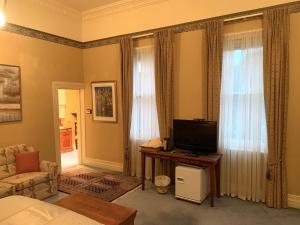 a living room with a television and a couch at Langley Estate, Bendigo in Bendigo