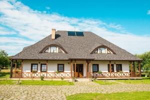 a large white house with a gambrel roof at Casa Strabunicului in Pîrteştii de Sus