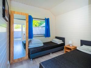 a room with two beds and a window with blue curtains at Balticus in Jarosławiec +82 photos
