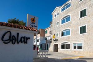 un bâtiment avec un panneau sur son côté dans l'établissement Solar Beach Inn, à Split