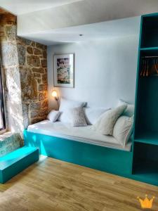 1 dormitorio con 1 cama en una habitación con una pared de piedra en Estafête en Sarrazac