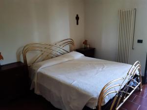 ein Bett in einem Schlafzimmer mit einem Kreuz an der Wand in der Unterkunft Appartamento nel verde tra Cinque Terre e Versilia in Barbarasco