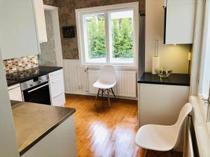 eine Küche mit einem weißen Stuhl und einem Fenster in der Unterkunft Villa Alex in Helsinki