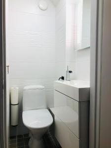 a white bathroom with a toilet and a sink at Villa Alex in Helsinki