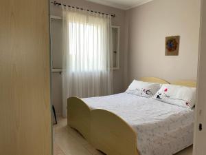 1 dormitorio con 1 cama con sábanas y almohadas blancas en Villetta Sabbia d'Oro en Torre Mozza