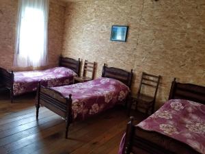 a room with four beds and a wall with a window at Makratela in Akhmety
