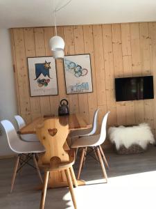 una mesa de madera y sillas en una habitación en Appartement 1 chambre, 4 personnes, en Champagny-en-Vanoise