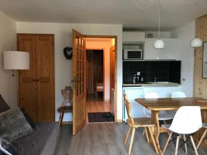 cocina y comedor con mesa y sillas en Appartement 1 chambre, 4 personnes, en Champagny-en-Vanoise